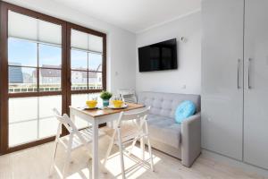 un soggiorno con tavolo, sedie e divano di Liliowa Seaside Apartments by Noclegi Renters a Dębki