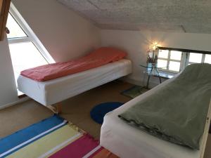 Cette petite chambre comprend 2 lits et une fenêtre. dans l'établissement Rainbows End B&B, à Sorø