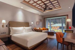 a bedroom with a bed and a living room at The Khyber Himalayan Resort & Spa in Gulmarg