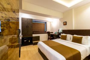 a hotel room with a bed and a desk at Hotel Larmont Luxury in Mumbai