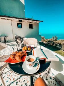 einen Tisch mit einem Teller Essen und einer Tasse Kaffee in der Unterkunft Gogo's Boutique Hotel in Dhërmi