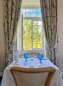 - une table avec des verres à vin et une fenêtre dans l'établissement PortoBay Serra Golf, à Santo da Serra