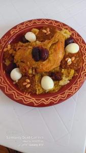 un plato de comida con carne y bayas. en دوار ابغاوة ازغيرة تروال سد الوحدة وزان, en Srija