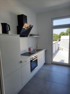 uma cozinha branca com um fogão e uma janela em Villa Mariensiel em Sande