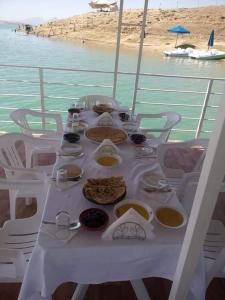 una mesa con comida en un barco en el agua en دوار ابغاوة ازغيرة تروال سد الوحدة وزان, en Srija