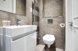 a bathroom with a white sink and a toilet at Woodview Serviced Apartments by Concept Apartments in London