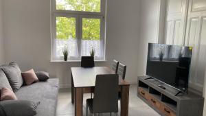 a living room with a couch and a table and a television at Villa Mariensiel in Sande