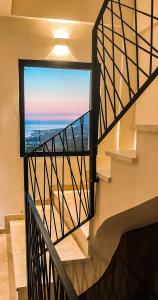 a staircase with a view of the ocean from a window at Gogo's Boutique Hotel in Dhërmi