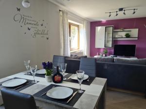 ein Esszimmer mit einem Tisch mit Tellern und Weingläsern in der Unterkunft Ferienwohnung Chrissi in Bischofsheim an der Rhön