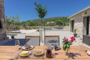 einen Holztisch mit Weingläsern und Blumen darauf in der Unterkunft Private Villa Bosilen Marina by Trogir Split airport Sibenik in Marina