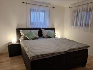 a bedroom with a large bed with two windows at Ferienwohnung Chrissi in Bischofsheim an der Rhön