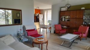 - un salon avec des chaises rouges et une table dans l'établissement La terrasse, à Poitiers