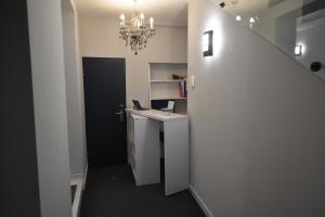 a bathroom with a sink and a staircase with a chandelier at Stadthotel Das Villach in Villach