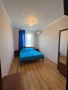 a bedroom with a blue bed in a room at Ararat & Svetlana in Alakhadzi