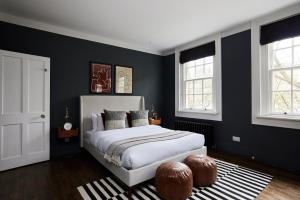a bedroom with a bed with black walls and windows at The Southwark Townhouse - Adorable 3BDR House with Garden in London