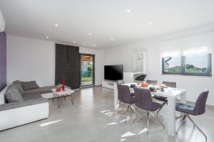 ein weißes Wohnzimmer mit Tisch und Stühlen in der Unterkunft Villa Antonina by SeeAdria Agency in Filipac