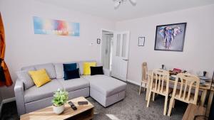 a living room with a couch and a table at E2M Stays Beautiful House Close To Heathrow Airport- Walking Distance To Thames River in Egham