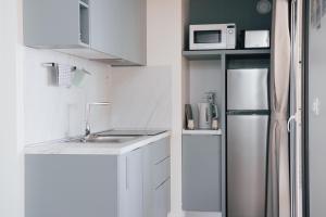 eine weiße Küche mit einer Spüle und einem Kühlschrank in der Unterkunft MOBILE HOMES SELCE - Lighthouse in Selce
