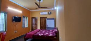 a bedroom with a bed and a ceiling fan at Goroomgo Neelachal Holiday Nibasa Puri in Puri