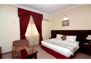 a hotel room with a bed and a window at Royalton Hotels Abuja in Abuja