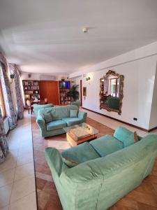 a living room with blue couches and a mirror at Hotel Meridiana in Sirmione