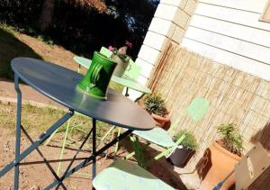 une table avec un pot vert assis au-dessus dans l'établissement Studio indépendant et chambres dans maison avec jardin-Carre de Soie, à Vaulx-en-Velin