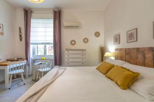 a bedroom with a large white bed and a desk at Affittacamere da Marianna in Alghero
