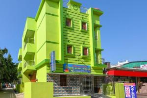 a green building with a sign in front of it at Goroomgo Neelachal Holiday Nibasa Puri in Puri