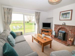 a living room with a couch and a fireplace at Dolafon in Pwllheli