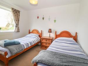 two twin beds in a room with a window at Dolafon in Pwllheli