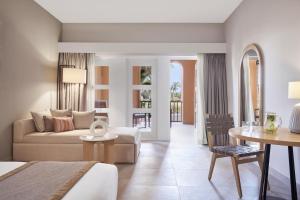 a hotel room with a bed and a living room at Steigenberger Golf Resort El Gouna in Hurghada