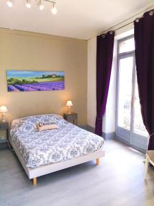 a bedroom with a bed and a large window at Le Relais Bastide de Cordes sur Ciel in Cordes-sur-Ciel