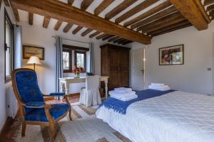 a bedroom with a bed and a chair and a desk at Maison "Jardin Gaillard" in Biéville-en-Auge +76 photos