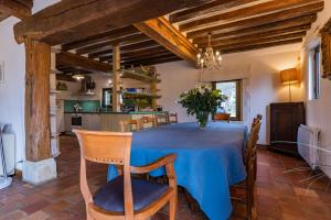 une cuisine et une salle à manger avec une table bleue et des chaises dans l'établissement Maison "Jardin Gaillard", à Biéville-en-Auge