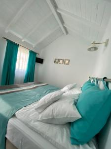 a bedroom with a bed with blue and white pillows at Breeze By The Lake - Cazare cu jacuzzi pe malul lacului 