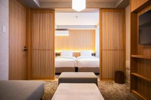 京都市にあるMiru Kyoto Gionのベッド2台とテレビが備わるホテルルームです。