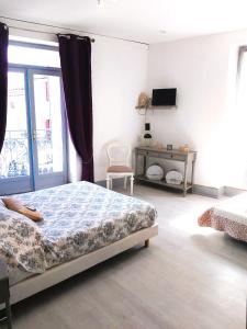 a bedroom with a bed and a tv on a wall at Le Relais Bastide de Cordes sur Ciel in Cordes-sur-Ciel