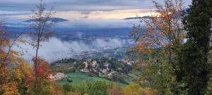 a town in the middle of a valley with clouds at Profumo di Bosco in Spoleto