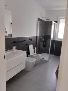 a bathroom with a toilet and a sink and a shower at Gioja suite in Quartu SantʼElena +25 photos