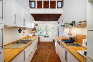 a kitchen with white cabinets and a large window at Pura Vida Falésia by The Portuguese Butler in Albufeira