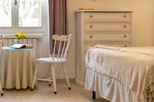 a bedroom with a bed and a chair next to a dresser at Affittacamere da Marianna in Alghero