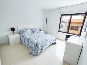 a white bedroom with a bed and a window at Céntrico apartamento de 2 dormitorios en La Laguna in Las Lagunas