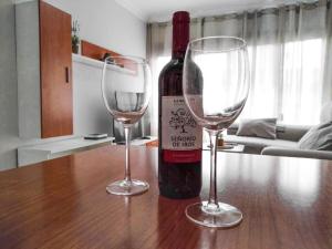 a bottle of wine and two wine glasses on a table at Céntrico apartamento de 2 dormitorios en La Laguna in Las Lagunas