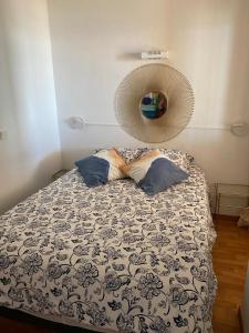een slaapkamer met een bed met een deken en kussens bij Appartement face à la mer in Cap d'Agde