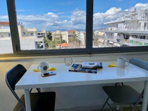 un tavolo bianco con due sedie e una finestra di Lovely 50 sq penthouse & 25 sq balcony @ Glyfada ad Atene