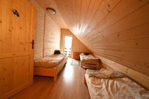 a room with three beds in a wooden room at Poziomkowy Dom- Wisła, Dom z bali, Sauna, Taras in Wisła