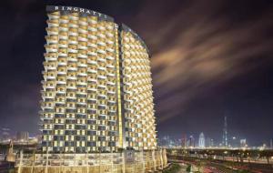 a tall building with a sign on it at night at Hayyak Homes-Luxury 1 bedroom Apartment in Dubai