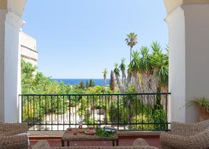 een balkon met uitzicht op de oceaan en palmbomen bij Villa Aimone in Marina Porto