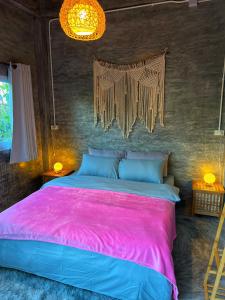a bedroom with a large bed with a pink blanket at Wonderland Jungle Hostel in Koh Tao