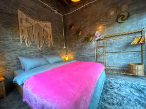 ein Schlafzimmer mit einem großen Bett mit einer rosa Decke in der Unterkunft Wonderland Jungle Hostel in Ko Tao